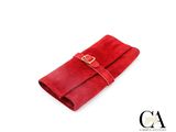 portefeuille en cuir rouge orné d'une boucle dorée sur fond blanc