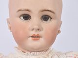 a close up of a doll with a white dress on