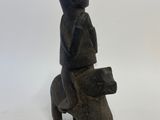 an old wooden statue of a woman sitting on a horse