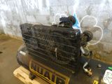 a compressor sitting on top of a pallet in front of a wall