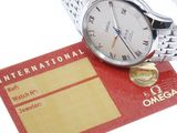 a silver watch and a red business card on a white surface