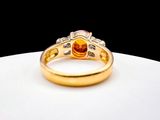 an image of a gold ring with an orange stone in the center