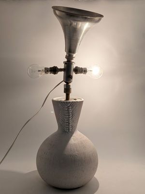 a white vase with a light bulb on top of it