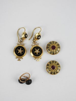 trois paires de boucles d'oreilles et une broche posées sur un fond blanc