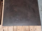 une palette en bois sur laquelle est posée une dalle noire