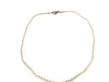 un collier de perles et de diamants sur fond blanc