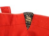 an image of a close up of a red dress with a black and gold label on it