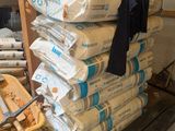 a pile of bags of cement sitting on top of a wooden cart