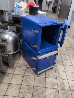 a blue cooler sitting on the floor in a kitchen