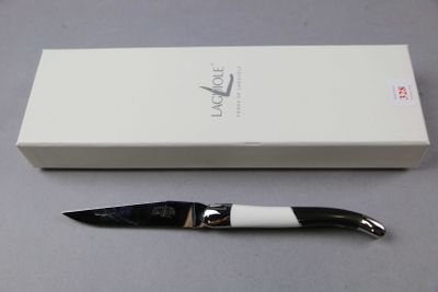 a black and white knife sitting next to a white box