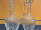 pair of clear glass decanters on a blue surface