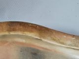 a silver plate with a cat on it on a table
