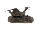 bronze sculpture of a bird on a rock with a white background