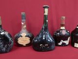 several bottles of wine are lined up on a red surface