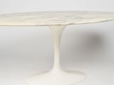 an oval marble dining table with a pedestal base
