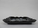 small black scallop bowl with flowers on the rim