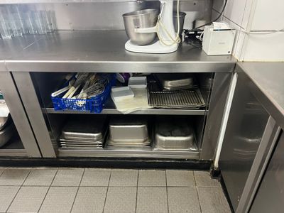 une cuisine équipée d'un plan de travail en inox et d'un mixeur