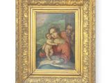 un tableau représentant une femme tenant un bébé dans ses bras, dans un cadre doré