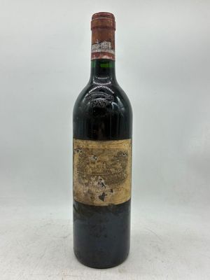 une vieille bouteille de vin posée sur une table blanche