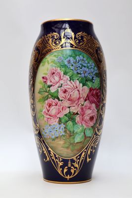 un vase sur lequel sont peintes des fleurs sur fond blanc