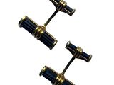 two pairs of black and gold cufflinks on a white background