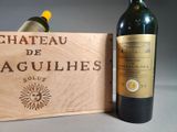 a bottle of wine next to a wooden box with a bottle of wine in it