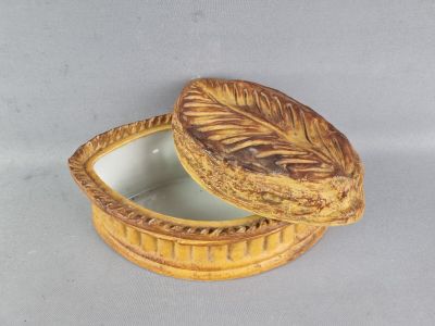 une petite boîte jaune avec un couvercle, posée sur une table