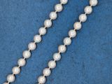 un gros plan d'un collier de perles blanches sur fond bleu