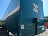 a green semi trailer parked in a parking lot
