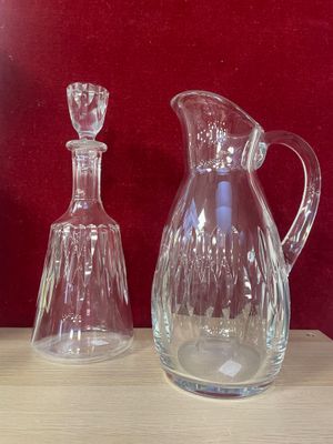 two glass vases sitting on a table next to each other