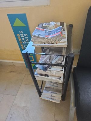 une pile de journaux posée sur un chariot à côté d'une chaise