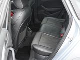 the back seats of a silver car with a black seat belt