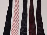 four ties are lined up in a row on a white surface