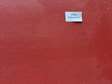 a red suitcase with a sticker on it sitting on a wooden floor