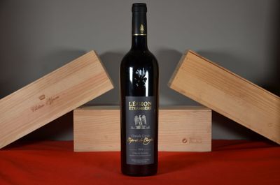 a bottle of wine sitting on a table next to two wooden boxes