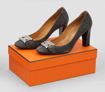 une paire de chaussures grises posée sur une boîte orange