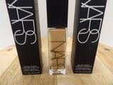 a close up of two bottles of nars cosmetics on a table