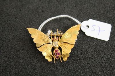 un gros plan d'une broche en forme de papillon sur laquelle est accrochée une étiquette de prix