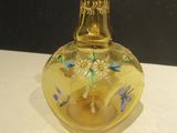 une bouteille en verre jaune contenant une bougie