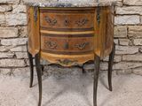 an old wooden chest of drawers with a marble top in front of a stone wall