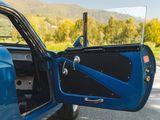 a blue car with its door open on the side of the road