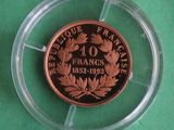 a close up of a coin in a plastic holder on a green surface