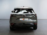 the rear end of a grey car in a white room