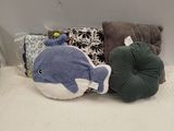 un lit sur lequel se trouvent deux oreillers et une baleine en peluche
