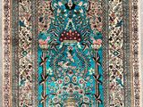 a blue rug with a bird and flowers on it