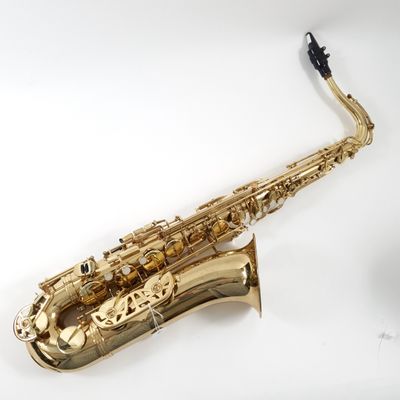a gold saxophone sitting on top of a white surface