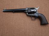 un pistolet posé par terre sur un fond marron