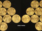 a close up of a bunch of gold coins on a black surface