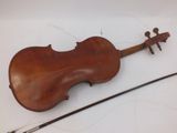 an old violin sitting on top of a white table next to a stick