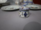 many plates and cups on the table with a blue and white lid